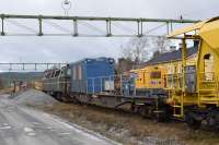 A late autumn scene with traces of early snow where two engineering trains are in the station sidings at Järpen in western Jämtland. Closer to the camera is a ballast train; this is loaded from the ballast heaps using the mechanical loader. Loco is Railcare TMZ 1418. Note the onboard generator and crew 'bothy' on an adapted flat wagon. The yellow building behind is Järpen Station. In the background is a rail grinder [see image 61633].<br><br>[Charlie Niven 30/10/2017]