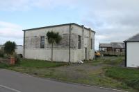 The last surviving building (the old sub-station) at the Argyll Colliery sits alongside the Machrihanish caravan park that now occupies the remainder of the site. For a while this was used as a pub known as the Laggan Bar but no longer. Argyll Colliery started producing coal in 1950 and was close to another mine of the same name that had closed in 1929. The first mine sent coal out to Campbeltown Harbour by canal  from Drumlemble and then the narrow gauge railway (which ran just behind the camera) but the new mine had to use road transport. It ceased production in 1967 although the pit head baths stood alongside the road until 2005 before demolition. [Ref query 25 October 2017].  [With thanks to Malcolm Chattwood for colliery information].<br>
<br><br>[Mark Bartlett 22/10/2017]