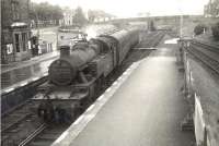 40170 comes off the Kirkcudbright branch under Ernespie Road bridge and into Castle Douglas station on a wet Monday in July 1956. The train is a stopping service for Dumfries.<br><br>[G H Robin collection by courtesy of the Mitchell Library, Glasgow 16/07/1956]