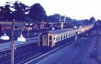 An eastbound service arrives at Brockenhurst on a July evening in 1971 as the last of the sun illuminates the EMU. On the left, the sidings are full of wagons and brake vans and bottom right a two car EMU waits with a service from the Lymington branch.<br><br>[John McIntyre /07/1971]