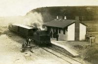 An interesting image of brand new (almost finished) Preesall station, on the 1908 extension of the line from Pilling to Knott End. 0-6-0T <I>Knott End</I> is pulling in with two of the Lancaster C&W veranda coaches and a guards van. Note the makeshift station sign in the foreground, presumably later replaced with a proper fitting. The station was only open for 22 years but after closure in 1930 goods trains continued to pass through until 1950.  <br><br>[Knott End Collection //1908]