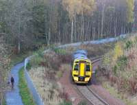 One man and his dog pause on their morning walk to observe the passage of the 0959 Tweedbank – Edinburgh as it turns north towards Torwoodlee on 9 November 2017. The observers are standing on the trackbed of the Peebles Railway, which ran parallel with the Waverley Route from Kilnknowe Junction up to this point before turning west towards Clovenfords [see image 58513].<br><br>[John Furnevel 09/11/2017]