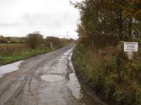 Looking east from Pockley Gates level crossing towards Nawton station, along the intensely used former trackbed now serving Beadlam Grange Farm seen in the left distance. A leaning concrete gate post can be seen by the notice, and concrete fence posts further along, seemingly from when the line was operational. <br><br>[David Pesterfield 15/11/2017]