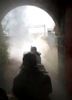 It's not every day that you see steam and OHL together. The miniature ride-on train at the Crewe Heritage Centre emerges from the artificial tunnel next to the WCML.<br><br>[Ken Strachan 03/04/2015]