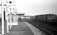 Looking north along platform 1 at Cambridge on 18 January 1976 as a DMU disappears into the distance and a Class 03 shunter stands with some parcel vans on the right.<br><br>[John McIntyre 18/01/1976]