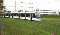 An airport bound Edinburgh tram drops down from a leafy Gyle Centre to pass below the A8 on 14 November 2016, just as it begins to rain. On the other side of the underpass the tram will run through the site of Edinburgh Gateway, not scheduled to open for another month [see image 57176].<br><br>[John Furnevel 14/11/2016]