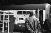 Running repairs are carried out on Mark 2 coach SC 5176 at Queen Street station in 1974. Under the watchful eye of a manager, C&W set to remove the glass from a broken window before replacing it with a piece of wood so that the coach can remain in service and the train can depart on time.<br><br>[John McIntyre //1974]