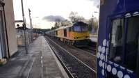 The 0928 to Edinburgh waits for departure time in Dunblane station on 28th November 2017, as Colas 60047 passes through with a freight service.<br>
<br>
<br><br>[David Prescott 28/11/2017]