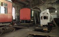 Inside 60B in Strathspey days with Highland Railway luggage van (no.5) in the back corner of the shed. On the right is the boiler off Austerity No.9 which was under repair at the time, 05 July 1991.<br><br>[John McIntyre 05/07/1991]