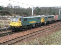 Close up of a pair of class 86 electric locomotives (86610+86612) about to bring the Coatbridge – Basford Hall containers through Carstairs on 8 March 2007. Built in 1965 these are examples of the 100 BR class AL6 units produced by BR Doncaster Works and the English Electric Vulcan Foundry during 1965/1966.  With a number of the class still in revenue earning service today (2017) they have proved to be one of the successes of BR's WCML electrification project.<br/> (One for the 'return on investment' buffs - not to mention the pantograph spotters.)<br><br>[John Furnevel 08/03/2007]