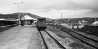 A quiet lunchtime looking north along the outer face of the island platform at Aviemore in April 1986. Beyond a pair of brake vans was a train of bolster wagons, some with recovered track panels.<br><br>[John McIntyre /04/1986]