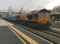 66.198 hauls an empty car train North at Bletchley on 20th February 2015. Notice the mothballed flyover in the background, and the platform extension in the foreground.<br><br>[Ken Strachan 20/02/2015]