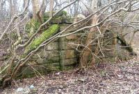 Surviving abutment of a former railway bridge that once spanned an access road just south of Glencorse, photographed in March 2016. The freight only single line ran from Glencorse goods yard to reach coal workings and a gasworks in the the Penicuik area. View north west from the footpath alongside the A701 on 13 March 2016. [See image 32818] <br><br>[John Furnevel 13/03/2016]