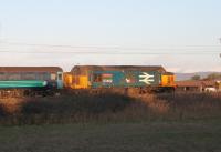 Snow on the Lake District mountains, and a low winter sun just illuminates the flanks of 37402 as it propels the 2C32 Carlisle to Preston service through Hest Bank on 8th December 2017. <br><br>[Mark Bartlett 08/12/2017]