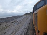 The line between Parton and Harrington has the Irish Sea on one side and crumbling cliffs on the other. Part of this stretch was reduced to single line a number of years ago to ease maintenance. 37401 propels 2C34 Carlisle to Barrow along the single line section, which has a 15mph speed limit, on 13th November 2017. <br><br>[Mark Bartlett 13/11/2017]