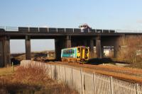 An Arriva Trains Class 153 single unit climbs Stormy Bank with a Shrewsbury to Cardiff Central stopping train on 8th December 2017. The unit is just passing under the M4 Motorway. To the left were the Reception Sidings of Margam Yard.<br>
<br>
<br><br>[Alastair McLellan 08/12/2017]