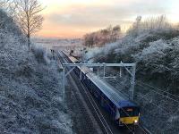 A slightly delayed 318267 leaves Bailleston for Motherwell in sub zero temperatures with a spectacular display of arcing from the pantograph on the icy wires. 11th December 2017<br><br>[Colin McDonald 11/12/2017]