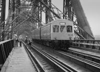 Met Cam DMU 101303 heads south across the Forth Bridge, passing an organised party visit in 1983.<br>
<br>
<br><br>[Bill Roberton //1983]