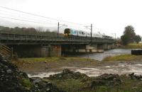 The First TransPennine 1116 ex-Glasgow Central crosses the Clyde at Lamington on a wet and gloomy Christmas Eve 2017, with the Southern Uplands shrouded in mist. Normally running to Manchester Airport, the train was scheduled to terminate at Lancaster on this occasion due to engineering works.  Photographed from one of the prominent mounds of rock and rubble created by NR when repairing the viaduct last year [see image 56733]. <br><br>[John Furnevel 24/12/2017]