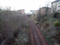 The Crawford footbridge, where I'm standing, plays a supporting role in the<br>
1951 Edinburgh short *The Singing Street* (<a href=http://movingimage.nls.uk/film/0799 target=external>See 3 minutes 50 seconds of the NLS Moving Image Archive</a>). In those days there were eight tracks under it; now there is but one, and that is disused. I'm looking towards Easter Road station site and the curve to Abbeyhill and Waverley was to the left. Note the surviving buffer from a headshunt. This was for the St Andrew Steel Works of Redpath Brown Ltd.<br>
<br>
<br><br>[David Panton 20/12/2017]