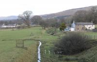 Looking north along the Clapham to Low Gill trackbed just south of the site of Barbon station in December 2017. The station closed to passengers in 1954 but freight and diverted trains continued to pass along the line until 1967. All the other stations on the line survive in private use but Barbon was demolished with the site turned over for housing development. This section of trackbed is now in use as farmland - note the now redundant stile. (Ref query 28 December 2017)<br><br>[Mark Bartlett 27/12/2017]