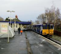 First stop on the Neilston branch is Muirend, one of several comfortable<br>
suburbs served by the Cathcart lines. On a cold 16th December 2017 a Neilston bound Class 314 pulls out as its last two (well, one and a half) passengers make<br>
their way to the Muirend Road exit.<br>
<br>
<br><br>[David Panton 16/12/2017]