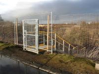 The gate on Whitehill Road giving access to the newly constructed steps [see image 62355]. View north on 1 January 2018 with the entrance to Millerhill Depot behind the camera. Newcraighall station is in the right background below the road bridge which carries the A1 over the railway.<br><br>[John Furnevel 01/01/2018]