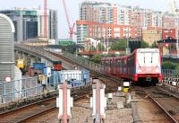 A Lewisham – Stratford service on the Docklands Light Railway, photographed shortly after leaving platform 2 at  Poplar station on 21 July 2005. The flyover, under which the train will shortly pass as it turns north, carries the eastbound DLR route from platform 1 towards Beckton. Part of the DLR's Poplar Depot can be seen on the left.<br><br>[John Furnevel 21/07/2005]