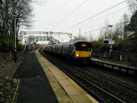 An Airdrie service calls at Drumchapel on the dull morning of 13 January. As so often the Gaelic version of the name on the sign (Druim a Caibeal) is questionable to say the least. Toponymists are pretty much agreed that Drumchapel means 'ridge of the horse' or 'horse's back', and is nothing to do with chapels as suggested.<br><br>[David Panton 13/01/2018]