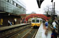 A Tyne & Wear Metro unit slows for the South Gosforth stop on its way to South Shields via the city centre in 1991. The network control centre is adjacent to the northbound platform. The old North Eastern Railway footbridge is a reminder of the main line days at this station. <br><br>[Mark Bartlett 15/03/1991]
