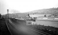 View north over the former permanent way depot at Loch Park, located around half a mile south of Hawick station, seen here in 1968. An unidentified 'Peak' type 4 is passing with a Carlisle bound freight.<br><br>[K A Gray //1968]