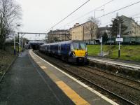 A Cumbernauld service calls at Duke Street on 13th January 2018 with, appropriately, Cumbernauld Road as a backdrop. Baking bread smells waft from the Hovis Bakery right next to the station and nearby is a car wash called 'Foam and Away'. A bit of<br>
local colour for you.<br>
<br>
<br><br>[David Panton 13/01/2018]