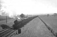 A V2 accelerates past Little Benton with an Edinburgh bound freight in 1962, shortly after crossing the A1068 Coast Road and passing the Wills cigarette factory in the right background. The fogman's hut and detonator placement lever in the foreground bear witness to the sea mist and fog regularly affecting this part of the ECML.<br><br>[K A Gray //1962]