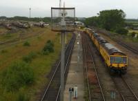 Tyne Yard has excellent photographic viewpoints from the long road over rail bridge, and there's always something new to see. There is an 08, a 66, and a 67 in the background of this shot; but pride of place goes to the Loram rail grinding train, which has echoes of 1950's Packard cars in its styling. View looks southwards in July 2015.<br><br>[Ken Strachan 11/07/2015]