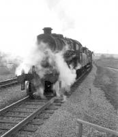 An Ivatt class 4 about to cross the bridge over the WCML at the south end of Kingmoor Yard with a down freight on the Waverley route, thought to be in late 1966. The 1963 link between the south end of the yard and Stainton Junction can be seen in the right background. <br><br>[Robin Barbour Collection (Courtesy Bruce McCartney) //1966]