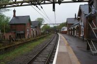 A view of the 'main line' platforms at Dinting looking east towards Hadfield on 12 May 2013. The electrification masts date from the 1500V DC era when this was the route between Manchester and Sheffield although the remaining sections to Hadfield and Glossop were converted to 25kV in 1984.<br><br>[John McIntyre 12/05/2013]