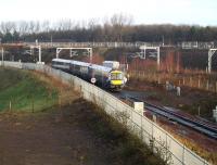 Just a hint of early morning February sunshine at Newcraighall South Junction as a Tweedbank – Edinburgh train comes off the double track section from King's Gate and passes over the Network Rail access pad.  The electrification masts serving the Millerhill freight lines run across the centre of the picture.<br><br>[John Furnevel 04/02/2018]