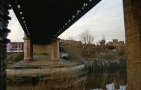 Under the Kelvin Viaduct looking west towards Partick in 2000. Another railway bridge passed underneath this one, coming from the right hand side (where Partick Central was located) to give the Caledonian access to the Pointhouse Shipyard and the warehouses along the Clyde. The scrapyard seen opposite is long gone, this had been an iron foundry and, much longer ago, the site of Partick Castle. Thus Castlebank Street ...<br><br>[Ewan Crawford //2000]