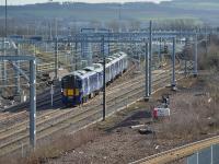 385103 leaves Millerhill emu depot on 20th February 2018, bound for Waverley and test runs to Dunbar. In the right foreground is the Borders Railway.<br>
<br>
<br><br>[Bill Roberton 20/02/2018]