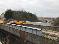 Baillieston station in the distance (centre right) with its rusting road bridge in the foreground seen on 22nd February, shortly before it was due to be demolished. The parapet extensions were fitted when the line was electrified in 2014.<br><br>[Colin McDonald 22/02/2018]