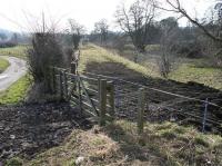 The southern approach to Jedfoot station in February 2018, looking south towards Jedburgh from alongside the A698. At this point the trackbed runs parallel with the Jed Water just off to the right. The remains of Jedfoot station lie behind the camera on the north side of the road [see image 63005]. <br><br>[John Furnevel 24/02/2018]