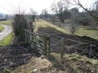 The southern approach to Jedfoot station in February 2018, looking south towards Jedburgh from alongside the A698. At this point the trackbed runs parallel with the Jed Water just off to the right. The remains of Jedfoot station lie behind the camera on the north side of the road [see image 63005]. <br><br>[John Furnevel 24/02/2018]