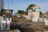 A London bound Class 387 calls at Watlington on 24 February 2018, however the signalbox still bears a former name of the station, Magdalen Road which was used when this was the junction for the line to Wisbech. The up platform has been located to the north of the LC since the station was reopened in 1975 but the former station buildings which were in use up until closure in 1968 can be seen in the driver's platform mirror. <br><br>[John McIntyre 24/02/2018]