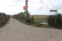 The double arrow sign at the junction of a minor road with this very minor lane seems a little out of place but it would be easy to miss Braystones without it. The station itself is down a steep hill beyond the visible section of the lane. 8th March 2018.<br><br>[Mark Bartlett 08/03/2018]
