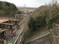 After a Sunday engineering possession during which it was hoped to cut up and remove the deck of the Muirhead Road overbridge, the 0812 to Dalmuir is seen in the distance arriving at Baillieston station. Proving somewhat more difficult to remove than anticipated, in the foreground much of the bridge remains. <br><br>[Colin McDonald 12/03/2018]