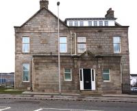 The refurbished offices of the GNSR Works, Inverurie, on 28 March 2018 looking east across Harlaw Road. Works buildings occupied much of the area between here and the main line, with several now converted or adapted for other uses since the works closed in 1969. [Ref query 28 March 2018] <br><br>[Andy Furnevel 28/03/2018]