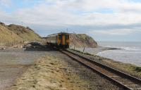 156486, heading from Barrow to Carlisle on 8th March 2018, slows to call at Nethertown, one of four trains a day in each direction timetabled for this request stop. The wide trackbed is a reminder that this cliff top station was once a passing point with two platforms but has been a plain single line since the 1970s.<br><br>[Mark Bartlett 08/03/2018]