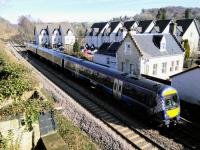 A southbound service passes the original Bridge of Allan station building before going under the A9 and entering the current station. Bridge of Allan is largely a Victorian creation, so its growth would have been greatly helped by the opening of this station.<br><br>[David Panton 20/03/2018]