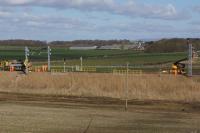 The overhead wiring team out at work on a sunny but cold 19 March 2018. This view east across Singleton Bank shows a road-rail lorry on the left carrying cable drums whilst an RRV elevated platform is allowing staff to attach the contact wire to regulation arm. Further elevated platforms were at work out of shot to the right.<br><br>[John McIntyre 19/03/2018]