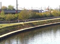 Nice day for a bicycle ride along the banks of the River Ouse at York on a pleasant afternoon on 6 June 2013. Meantime, in the background beyond the trees, an East Coast HST is accelerating away from York station with a northbound train.<br><br>[John Furnevel 06/06/2013]